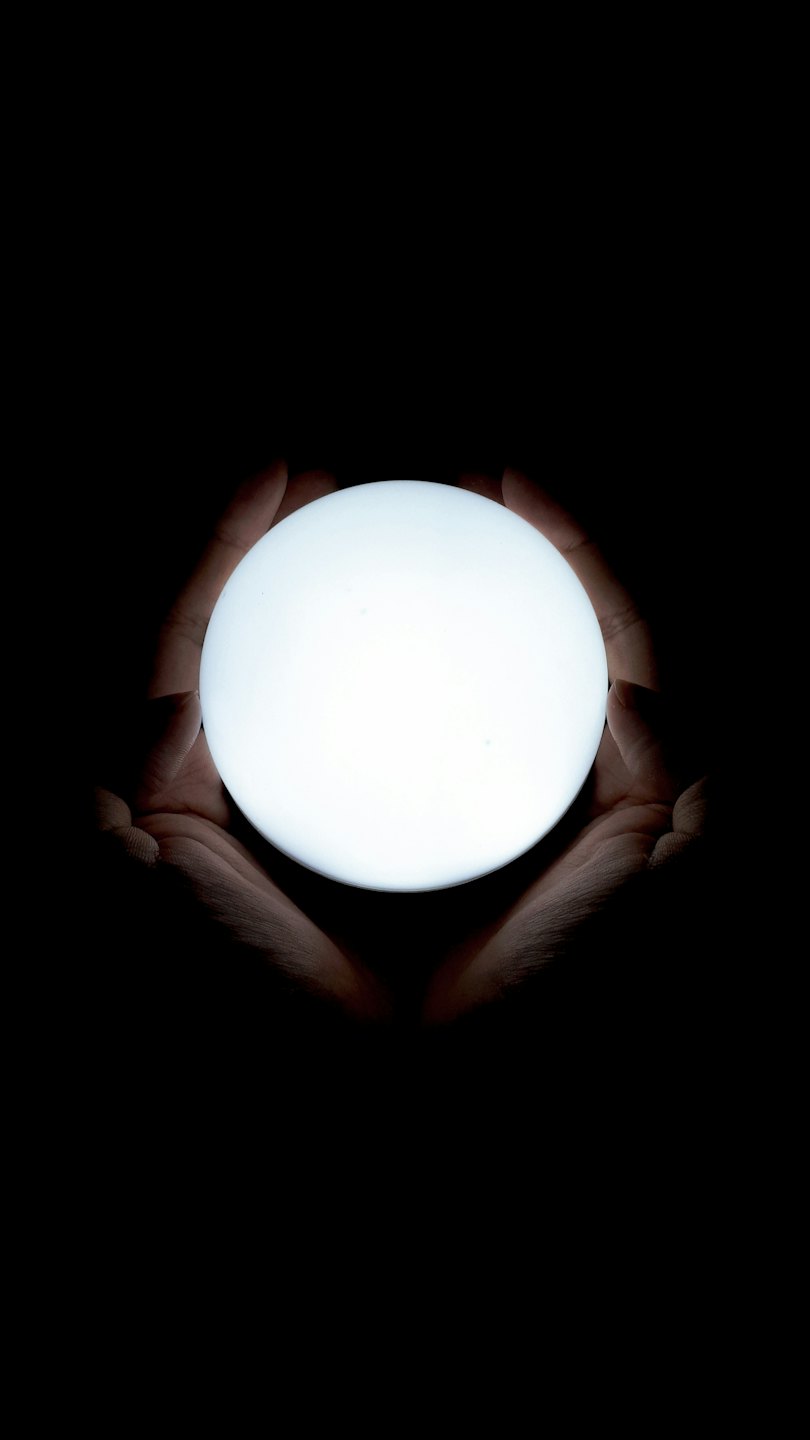Due mani che tengono una sfera bianca luminosa.